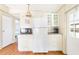 Kitchen with white appliances, cabinets, and wood flooring at 6168 Partridge Ave, Englewood, FL 34224