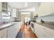 Bright and functional kitchen featuring white cabinets, modern appliances, and laminate flooring at 6168 Partridge Ave, Englewood, FL 34224