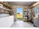 A utility room or workroom featuring laundry hookups, storage shelves, and exterior access at 6168 Partridge Ave, Englewood, FL 34224