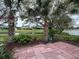 Serene backyard featuring a red tile patio and beautiful water views framed by mature trees at 67 Marker Rd, Rotonda West, FL 33947