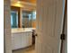 Well-lit bathroom featuring a vanity, large mirror, and a shower with glass doors at 67 Marker Rd, Rotonda West, FL 33947
