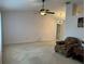 Spacious living room features plush carpeting, ceiling fan, and a modern chandelier for comfortable living at 67 Marker Rd, Rotonda West, FL 33947