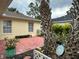 Cozy patio area with red pavers, surrounded by lush greenery, and a sunny yellow exterior at 67 Marker Rd, Rotonda West, FL 33947
