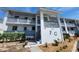 Two-story condo with balconies and gray railings, green shrubbery and landscaping in front at 6800 Placida Rd # F294, Englewood, FL 34224