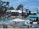 Community pool surrounded by lounge chairs, tropical landscaping, and condo buildings at 6800 Placida Rd # F294, Englewood, FL 34224
