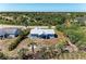 Aerial view of a blue house with a metal roof in a lush, green area at 7360 David Blvd, Port Charlotte, FL 33981