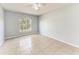 Bright bedroom with tile flooring, ceiling fan, and a view of the yard through a large window at 7360 David Blvd, Port Charlotte, FL 33981