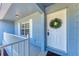 Charming front porch featuring white railing, a wreath on the front door, and textured walls at 7360 David Blvd, Port Charlotte, FL 33981
