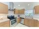 Updated kitchen with stainless steel appliances, light wood cabinets, and tile flooring at 7360 David Blvd, Port Charlotte, FL 33981