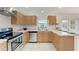 A well-lit kitchen with stainless steel appliances, wood cabinetry, and tile floors at 7360 David Blvd, Port Charlotte, FL 33981