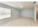 Bright main bedroom with a ceiling fan, tile floors, and large window at 7360 David Blvd, Port Charlotte, FL 33981