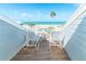 Relaxing balcony featuring chairs with views of palm trees and a distant glimpse of the ocean at 7536 Palm Island S Dr # 1522, Placida, FL 33946