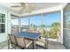 Relax on the screened balcony with ocean views, dining set, ceiling fan, and pleasant scenery at 7536 Palm Island S Dr # 1522, Placida, FL 33946