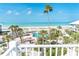Expansive beach view showcasing a pool, lush palm trees, and the serene ocean from an elevated vantage point at 7536 Palm Island S Dr # 1522, Placida, FL 33946