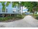Picturesque beach home with a long driveway, meticulous landscaping and a light blue exterior at 7536 Palm Island S Dr # 1522, Placida, FL 33946
