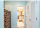 Hallway view leading to a bathroom, showcasing a dresser and closet with modern design elements at 7536 Palm Island S Dr # 1522, Placida, FL 33946