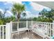 Charming white bench and table on a sunny patio with tropical foliage in the background at 7536 Palm Island S Dr # 1522, Placida, FL 33946