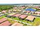 An aerial view of a community featuring a tranquil lake surrounded by well-maintained homes and lush greenery at 7620 Raptor Ct, North Port, FL 34287