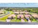 Aerial view showcases a beautiful neighborhood with well-manicured lawns, mature trees and a serene pond at 7620 Raptor Ct, North Port, FL 34287