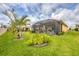 Well-maintained backyard featuring a screened-in patio area, tropical landscaping, and lush green lawn at 7620 Raptor Ct, North Port, FL 34287