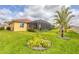 Well-maintained backyard with a tropical landscaping, a screened-in patio, and lush green lawn at 7620 Raptor Ct, North Port, FL 34287