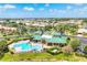Aerial view of a community clubhouse, pool, and lounge chairs surrounded by palm trees and lush landscaping at 7620 Raptor Ct, North Port, FL 34287