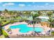 Community pool with lounge chairs and landscaping, surrounded by lake and palm trees at 7620 Raptor Ct, North Port, FL 34287