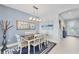 Dining room with a rectangular table, four chairs, modern light fixture, and a decorative mirror at 7620 Raptor Ct, North Port, FL 34287