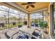 Inviting screened patio featuring a ceiling fan, white table with seating, and view of the manicured backyard at 7620 Raptor Ct, North Port, FL 34287