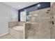 Bright bathroom featuring a soaking tub and a glass-enclosed shower, complemented by tiled walls and modern fixtures at 7620 Raptor Ct, North Port, FL 34287
