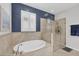 Bright bathroom with a soaking tub and a glass-enclosed shower, complemented by tiled walls and fixtures at 7620 Raptor Ct, North Port, FL 34287
