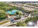 Aerial view of well-maintained tennis courts surrounded by trees and landscaping at 7620 Raptor Ct, North Port, FL 34287