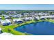 Aerial view showcasing the community's lake, surrounding homes, landscaping, and mature palm trees at 809 Tangerine Woods Blvd # 215, Englewood, FL 34223