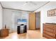 Cozy bedroom with wood-look floors and closet, complemented by a television at 809 Tangerine Woods Blvd # 215, Englewood, FL 34223