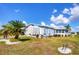 Quaint home featuring well-maintained landscaping and a lush palm tree on a sunny day at 809 Tangerine Woods Blvd # 215, Englewood, FL 34223