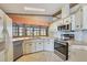 Bright kitchen featuring white appliances, tile floors, and a window overlooking the yard at 809 Tangerine Woods Blvd # 215, Englewood, FL 34223