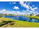 Scenic view of the lake with lush green banks, residential houses in the distance, and a beautiful sky at 809 Tangerine Woods Blvd # 215, Englewood, FL 34223