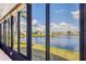 Relaxing view of the community lake from the screened lanai with lush green grass and beautiful landscaping at 809 Tangerine Woods Blvd # 215, Englewood, FL 34223