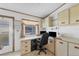 Efficient office space with built-in desk, cabinets, and natural light from the window at 809 Tangerine Woods Blvd # 215, Englewood, FL 34223