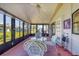 Enclosed lanai with table and chairs features views of the grassy lawn at 809 Tangerine Woods Blvd # 215, Englewood, FL 34223