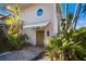Charming front entrance with brick pathway, wooden door and covered porch, surrounded by lush tropical landscaping at 11000 Placida Rd # 2702, Placida, FL 33946