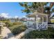 Charming white gazebo overlooking the water with lush landscaping and a beautiful shade tree at 11000 Placida Rd # 2702, Placida, FL 33946