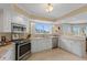 Well-lit kitchen featuring granite countertops, stainless steel appliances, and white cabinetry at 11000 Placida Rd # 2702, Placida, FL 33946