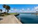 Scenic waterfront view with a dock, American flag, and tranquil water extending to the horizon under a blue sky at 11000 Placida Rd # 2702, Placida, FL 33946