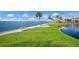 Waterfront view showing green grass area with bench and waterfront properties beyond at 11000 Placida Rd # 2702, Placida, FL 33946