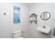Half bathroom featuring a sink, mirror, toilet, and decorative shelving at 130 Sand Dollar Ln, Englewood, FL 34223