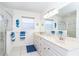 Bright bathroom with a double vanity, large mirror, and tiled walk-in shower at 130 Sand Dollar Ln, Englewood, FL 34223
