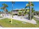 Bright two-story house with a screened porch and mature palms, surrounded by a white picket fence at 130 Sand Dollar Ln, Englewood, FL 34223