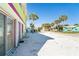 Side yard with palm trees, stone ground cover and a sliding glass door to the residence at 130 Sand Dollar Ln, Englewood, FL 34223