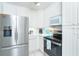 Close up of stainless steel refrigerator and modern appliances in a white kitchen at 130 Sand Dollar Ln, Englewood, FL 34223